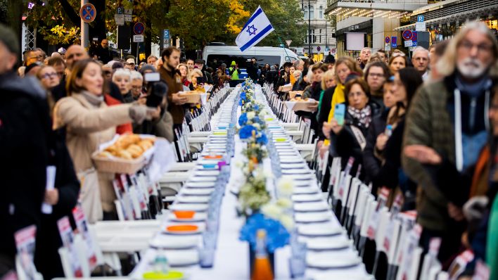 Ein festlich gedeckter Schabbat-Tisch mit 220 leeren Stühlen, stellvertretend für die 220 israelischen Geiseln der Hamas, ist bei einer Solidaritätsaktion mit Schabbat-Gebet der Gemeinde zu Berlin in der Fasanenstraße in Berliner Bezirk Charlottenburg-Wilmersdorf zu sehen (Quelle: dpa/Christoph Soeder)
