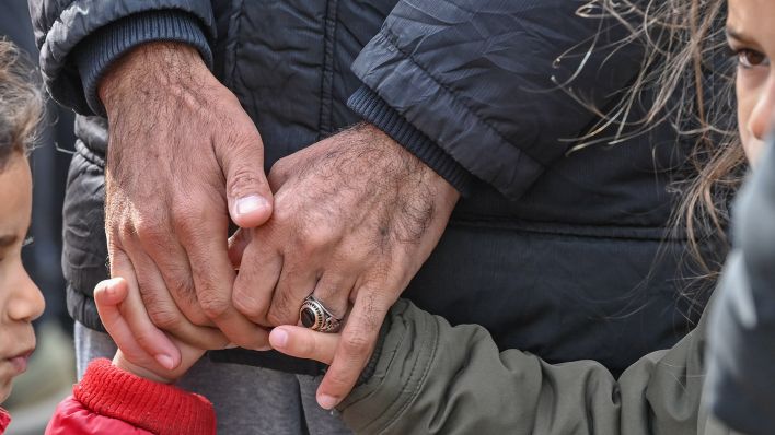 Symbolbild:Ein Vater hält die Hände seiner beiden Töchter in der Zentralen Erstaufnahmeeinrichtung für Asylbewerber (ZABH) des Landes Brandenburg.(Quelle:dpa-Zentralbild/P.Pleul)