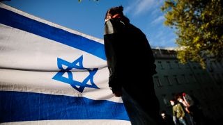 Symbolbild:Eine Teilnehmerin nimmt mit einer israelischen Flagge an einer Solidaritätsbekundung in Berlin teil.(Quell:dpa/C.Koall)