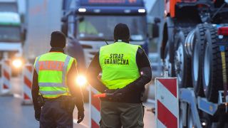 Archivbild: Ein Bundespolizist und ein polnischer Grenzschützer stehen an der Autobahn A12 am ehemaligen Grenzübergang in Swiecko und beobachten den Transitverkehr in Richtung Polen. (Quelle: dpa/P. Pleul)