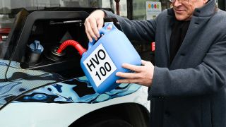 Symbolbild: Ein Mann füllt mit einem Kanister HVO100-Kraftstoff den Tank eines Stadtbusses. (Quelle: dpa/M. Merz)