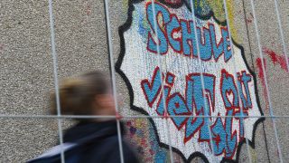 Symbolbild: Ein Mädchen läuft an der Fichtenberg-Oberschule im Berliner Steglitz an Graffiti mit dem Schrift "Schule mit Vielfalt" vorbei. (Quelle: dpa/L. Ducret)
