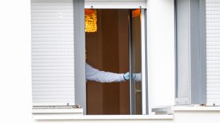 Ein Mitarbeiter der Spurensicherung schließt in ein Wohnhaus in Berlin-Gesundbrunnen ein Fenster. Dort soll eine Frau ihr zweijähriges Kind getötet haben. (Quelle: dpa/Fabian Sommer)