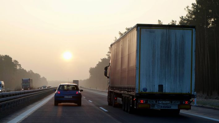 Symbolbild:Autos und Lastkraftwagen bei Sonnenaufgang auf der A12.(Quelle:imago images/F.Sorge)