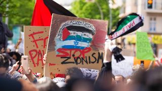 Symbolbild:Ein selbstgemaltes Schild mit der Aufschrift "Stop Zionism" wird bei einer Demo hochgehalten.(Quelle:imago images/S.Zeitz)