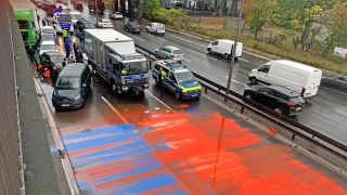 Die beschmierte Fahrbahn wird von Einsatzkräften der Polizei gesperrt.(Quelle:rbb/K.Breinig)