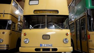 Es sind drei gelbe, historische BVG-Busse zu sehen.