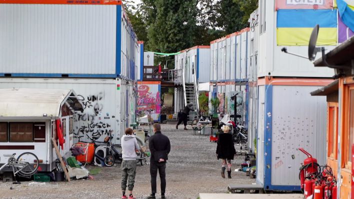 Menschen stehen in einem Trailerpark in Lichtenberg vor den Containern. (Quelle: rbb)