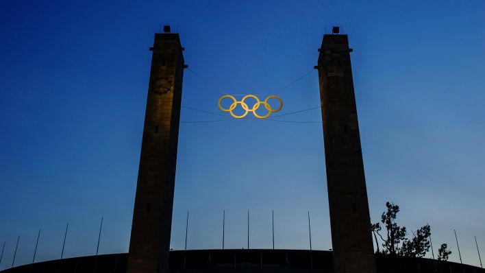 Symbolbild: Die Olympischen Ringe am Olympiastadion (Quelle: dpa/Paul Zinken)