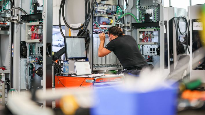 Ein Mitarbeiter von Siemens arbeitet an Schnellladesäulen vom Typ «Sicharge D» für E-Autos. (Quelle: dpa/Jan Woitas)