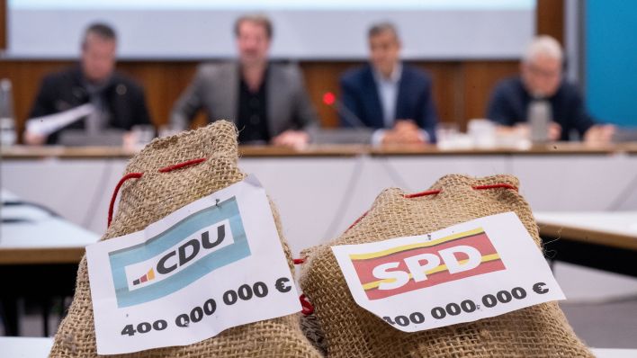 Zwei Säckchen, auf denen "CDU 400 000 000 €" und "SPD 400 000 000 €" steht, liegen am 20.11.2023 während eines Pressegesprächs zum Berliner Doppelhaushalt 2024/25 auf einem Tisch. (Quelle: Picture Alliance/Sebastian Gollnow)