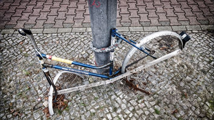 Symbolbild: Ausgeschlachtetes Fahrrad ohne Raeder und Sattel an Laternenpfahl. (Quelle: dpa/GTI)