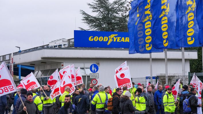 Mitarbeiter des Unternehmens der Reifenproduktion von Goodyear demonstrieren nach einer Betriebsversammlung vor dem Werk mit Fahnen der Industriegewerkschaft Bergbau, Chemie, Energie (IG BCE). (Quelle: dpa/S. Stache)