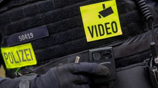 Ein Polizist schaltet die Bodycam auf seiner Uniform ein, aufgenommen bei einem Pressetermin zur Ausweitung des Einsatzes von Bodycams bei Berliner Polizei und Feuerwehr. (Quelle: dpa/Monika Skolimowska)