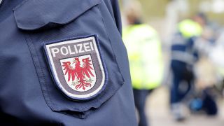 Symbolbild: Wappen der Polizei Brandenburg auf einer Uniform. (Quelle: dpa/Geisler)