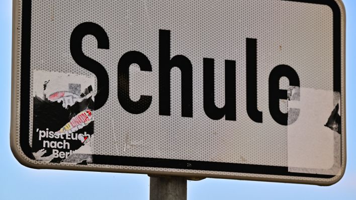 Symbolbild: Ein teilweise entfernter rechtsradikaler Aufkleber ist an einem Schild «Schule» zu sehen. (Quelle: dpa/Patrick Pleul)