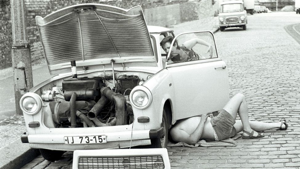Zwei Personen reparieren am 29.06.1984 einen Trabi, Ost-Berlin. (Quelle: dpa/Caro/Teich)