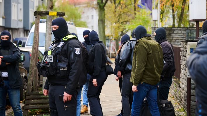 16.11.2023, Berlin: Polizisten und andere Personen verlassen das Anwesen eines Gebäudes in Neukölln. (Quelle: dpa/Annette Riedl)