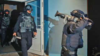 Spezialkräfte verlassen am 07.11.2023 bei einer großangelegten Razzia der Bundespolizei und Landespolizei Brandenburg ein Haus in Weißensee. (Quelle: dpa-Bildfunk/Paul Zinken)