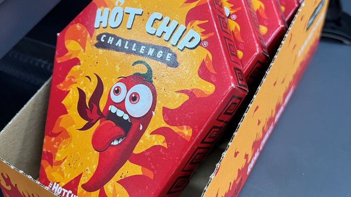 Mehrerer Packungen der "Hot Chip Challenge" liegen bei einem Kiosk neben der Kasse. (Quelle: dpa/Doreen Garud)