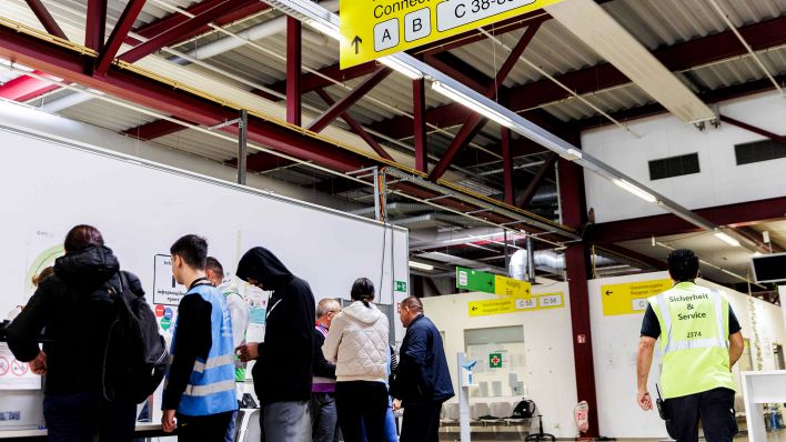 Menschen registrieren sich in der Empfangshalle des Ankunftszentrums Tegel. (Quelle: dpa/Carsten Koall)