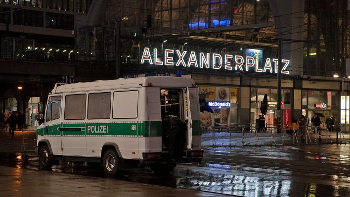 Ein Polizeifahrzeug steht am 31.12.2021 an einer Absperrung am Alexanderplatz in Berlin Mitte. (Quelle: Picture Alliance/Paul Zinken)