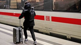 Menschen laufen mit Koffer am frühen Morgen des 07.12.2023 durch den Berliner Hauptbahnhof. (Quelle:picture alliance/dpa/F.Sommer)