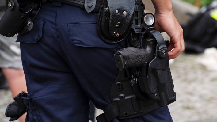 Symbolbild:Ein Polizeibeamter steht bei einem Einsatz in Berlin.(Quelle:picture alliance/dpa/P.Zinken)