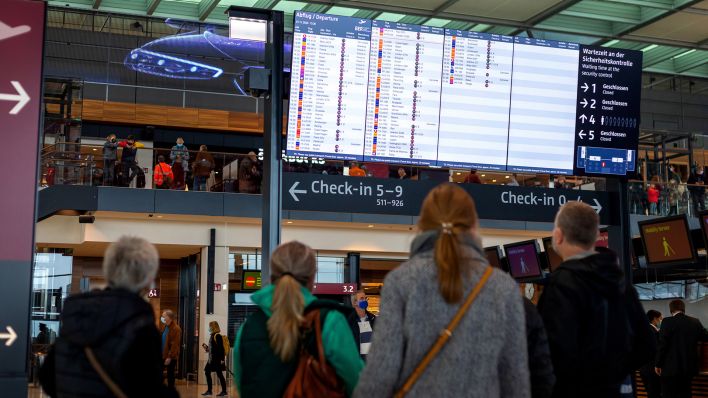 Archivbild: Fluggaeste schauen auf die Anzeigetafel im BER-Terminal. (Quelle: dpa/A. Franke)