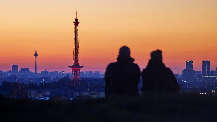 Symbolbild: Ein Paar sitzt auf dem Drachenberg und beobachtet den Sonnenaufgang. (Quelle: dpa/Jörg Carstensen)