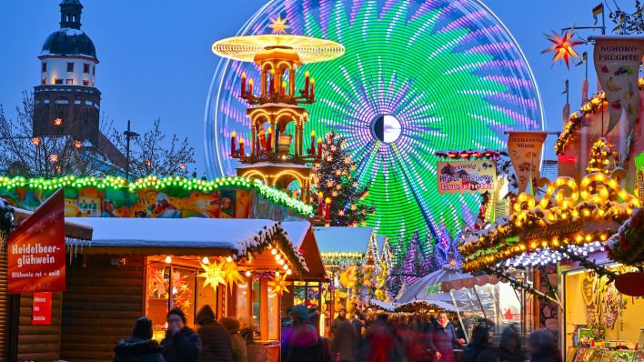 Ein Riesenrad und eine Pyramide drehen sich auf dem Cottbuser Weihnachtsmarkt der 1000 Sterne am späten Nachmittag. (Quelle: dpa/Patrick Pleul)