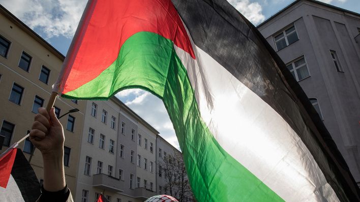 Bei einer pro-palästinensischen Demonstration am 8. April 2023 hält eine Frau in Berlin eine Flagge in der Hand. (Quelle: Picture Alliance/Michael Kuenne)