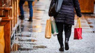 Eine Passantin geht mit Einkaufstaschen auf der Einkaufsmeile Schloßstraße im Stadtteil Steglitz. (Quelle: dpa/Christoph Soeder)