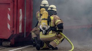 Symbolbild: Feuerwehrleute löschen am 29.11.2019 während einer Vorführung ein nachgebautes Wohnzimmer. (Quelle: Picture Alliance/Paul Zinken)