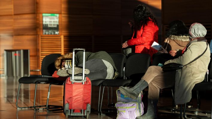 Symbolbild: Reisende warten im Terminal des BER. (Quelle: dpa/Paul Zinken)