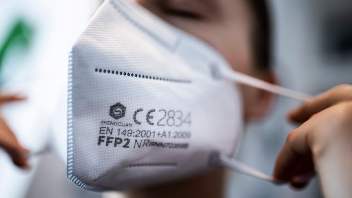 Symbolbild: Eine Frau setzt eine FFP2-Maske auf. (Quelle: dpa/Florian Gaertner)