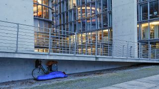 In einem Schlafsack schläft am 10.11.2023 ein Obdachloser am Paul Loebe Haus in Berlin. (Quelle: Picture Alliance/Jochen Eckel)