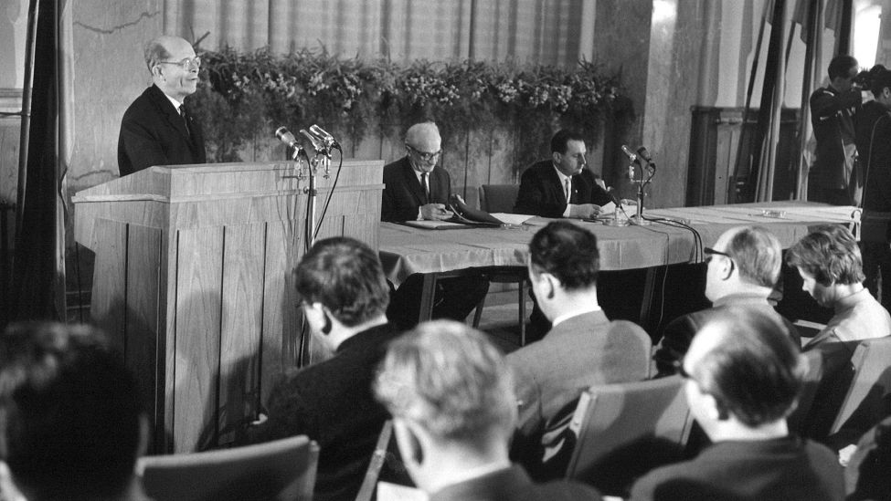 Der stellvertretende DDR-Ministerpräsident Alexander Abusch (l) gibt am 17. Dezember 1963 bekannt, dass am gleichen Tag das Protokoll über die Ausgabe von Passierscheinen an Westberliner für Verwandten-Besuche in der Hauptstadt der DDR an den Feiertagen unterzeichnet worden ist. (Quelle: ADN Zentralbild)