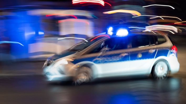 Ein Polizeiauto fährt am 01.10.2023 mit Blaulicht nach Einbruch der Dunkelheit über eine Straße der Hauptstadt. (Quelle: dpa/Wolfram Steinberg)