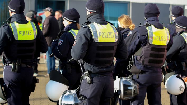 Symbolbild: Bewaffnete Polizisten mit Schutzweste auf Streife. (Quelle: dpa/Koch)