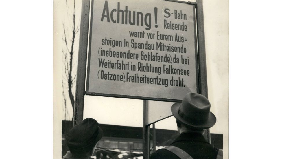 26. Juni 1953: Fahrgäste der S-Bahn werden in Spandau an der Grenze zur DDR mit Schildern informiert. (Quelle: dpa/Keystone Pictures USA)