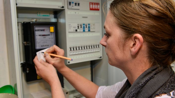 Symbolbilder: Frau liest Stromverbrauch vom Zähler ab. (Quelle: dpa/Niehoff)