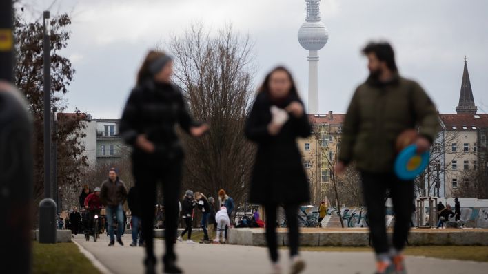 Symbolbild: Spaziergänger gehen im Winter vor dem Berliner Fernsehturm durch den Mauerpark. (Quelle: dpa/Soeder)