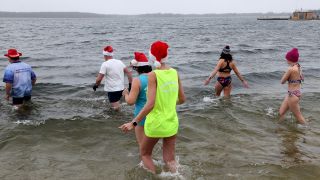 Die Mitglieder des Winter-Schwimmvereins «Pirrlliepausen» gehen zu ihrem traditionellen Weihnachtsbad in den vier Grad kalten Senftenberger See. (Quelle: dpa/Wüstneck)