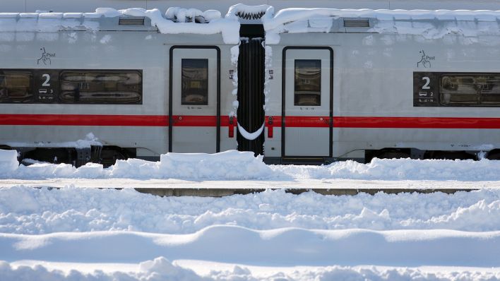 Ein mit Schnee bedeckter ICE steht am 03.12.2023 im Hauptbahnhof München. (Quelle: dpa-Bildfunk/Karl-Josef Hildenbrand)