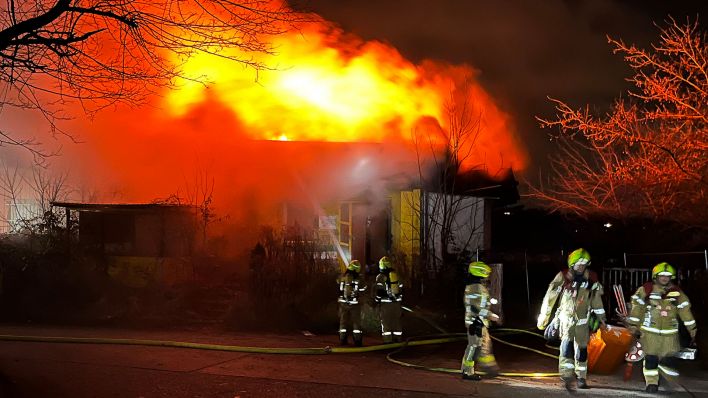 Einsatzkräfte der Feuerwehr löschen einen Brand in einer leerstehenden Lagerhalle in Berlin-Hellersdorf. (Quelle: dpa/Dominik Totaro)