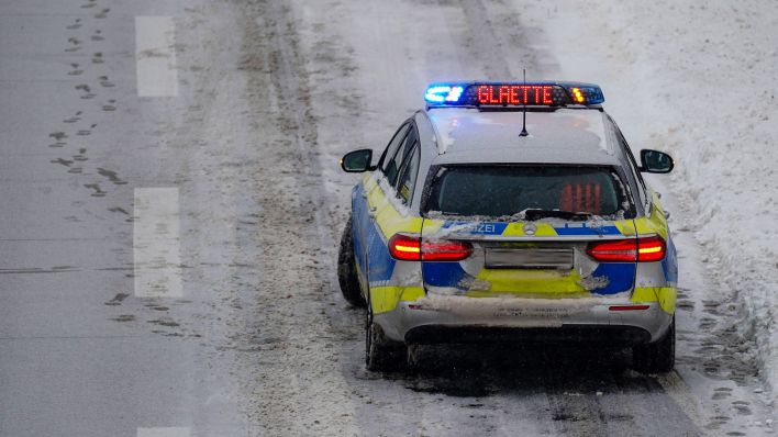 Symbolbild:Ein Polizeiauto zeigt den Warnhinweis "Glätte" an.(Quelle:imago images/LausitzNews.de/J.Kaczmarek)