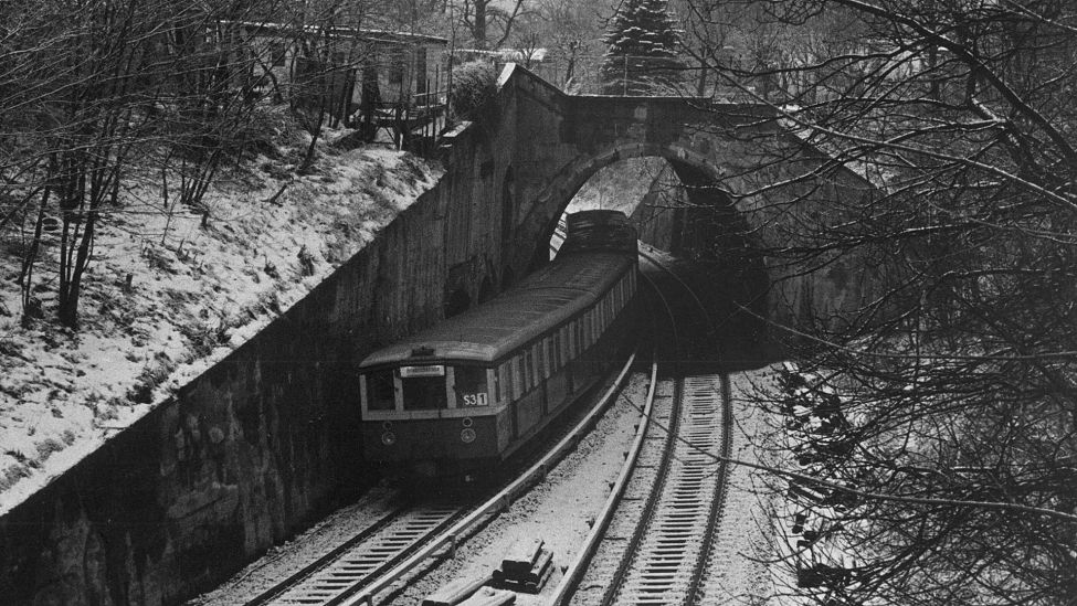 Ein S-Bahnzug der Baureihe 477 passiert am 03.12.1985 von Wannsee nach Friedrichstraße die verschneiten Ueberwerfungsbauwerke zwischen den Bahnhöfen Grunewald und Westkreuz. (Quelle: Imago Images/Jürgen Heinrich)