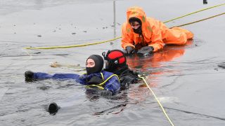 Mitglieder der DLRG demonstrieren eine Rettung aus dem Eis (Quelle: dpa/Paul Zinken)