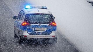 Symbolbild:Ein Polizeifahrzeug bei Schneefall im Einsatz.(Quelle:picture alliance/dpa-Zentralbild/R.Hirschberger)